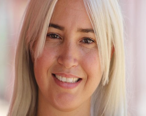 Mujer joven descansando cómodamente en su sala haciendo estiramientos de cuello